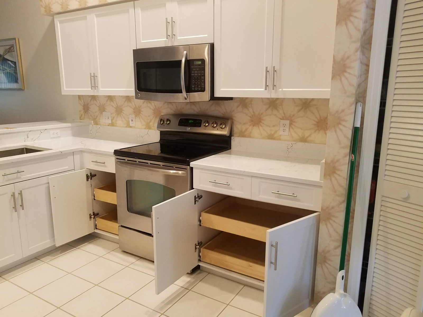 Two lower cabinets opened to show wood rollout shelves behind the doors