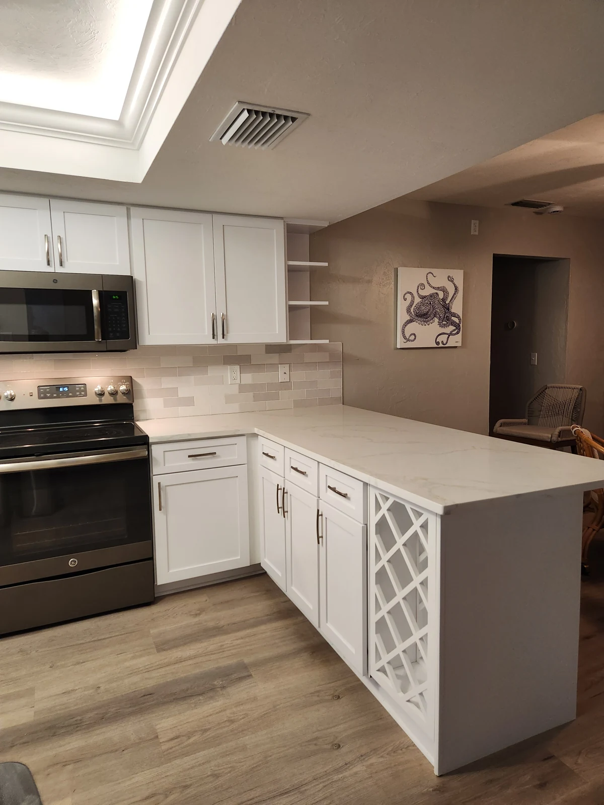 Refaced cabinet doors, drawers and an open storage section at the end of the peninsula