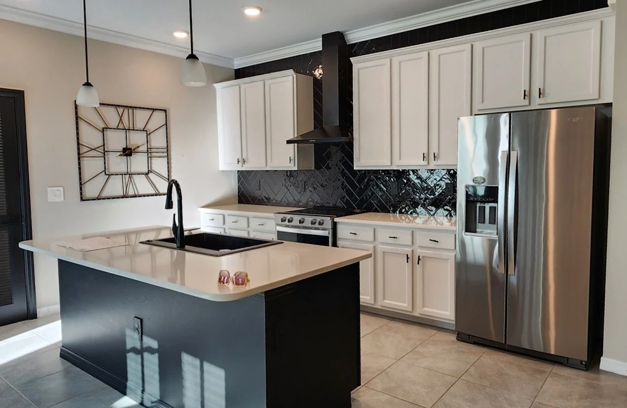 Kitchen with the existing white raised-panel door style, black herringbone backsplash and a dark island